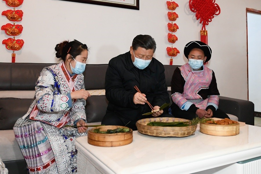 2021年2月3日下午，習(xí)近平在貴州畢節(jié)市黔西縣新仁苗族鄉(xiāng)化屋村苗族村民趙玉學(xué)家，同一家人邊聊家常邊制作當(dāng)?shù)貍鹘y(tǒng)節(jié)日食品黃粑。新華社記者 李學(xué)仁 攝